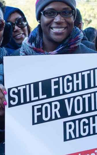 A volunteer holding a sign in support of voting rights